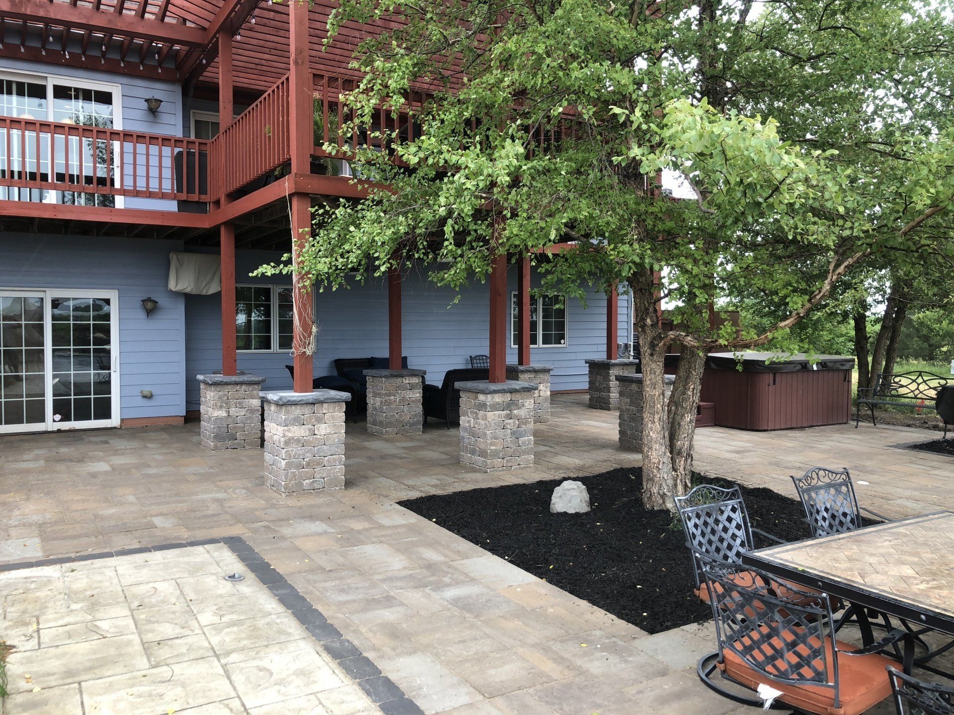 A large house with a patio and a hot tub in front of it.
