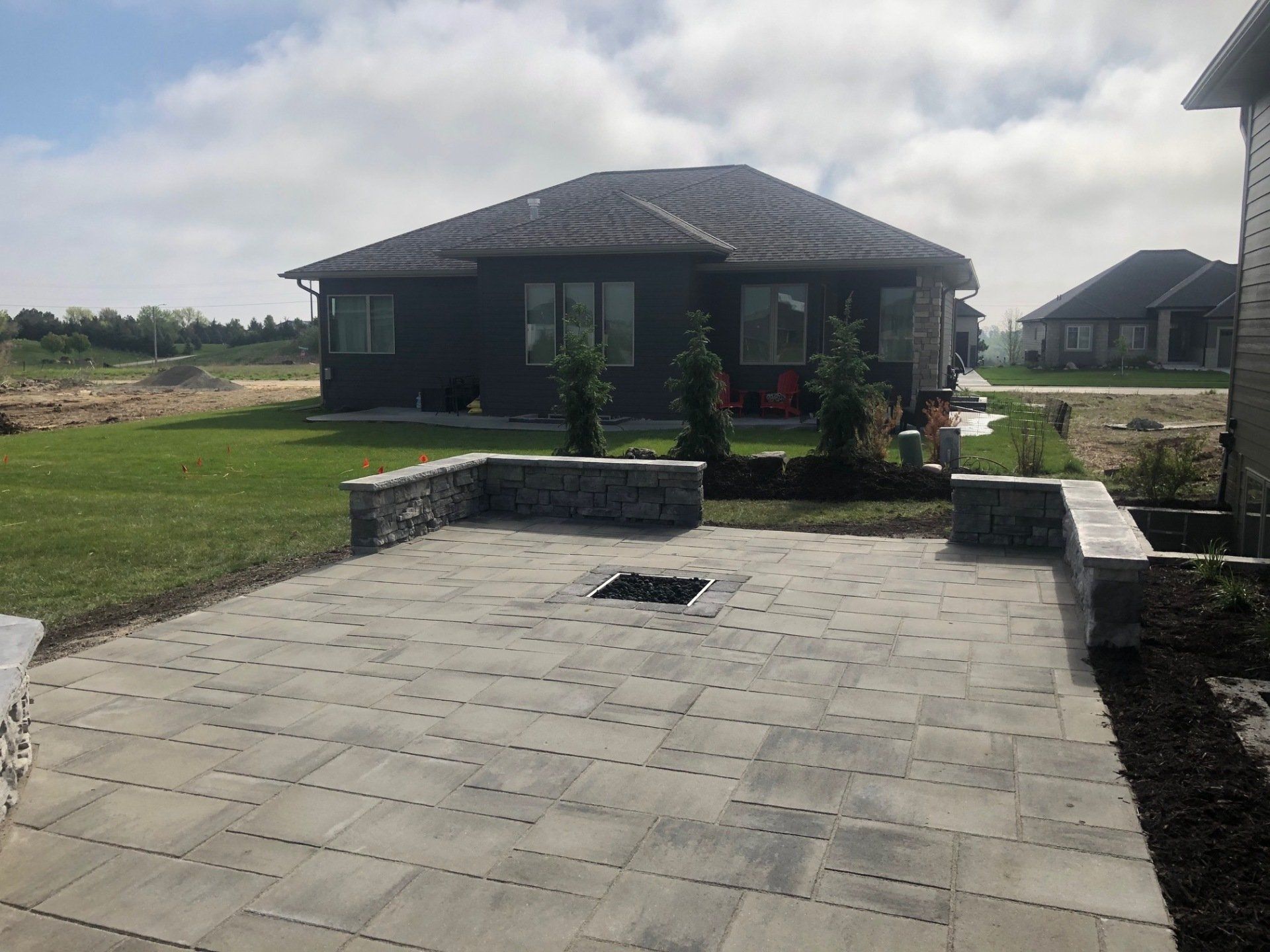 A patio with a fire pit in front of a house.