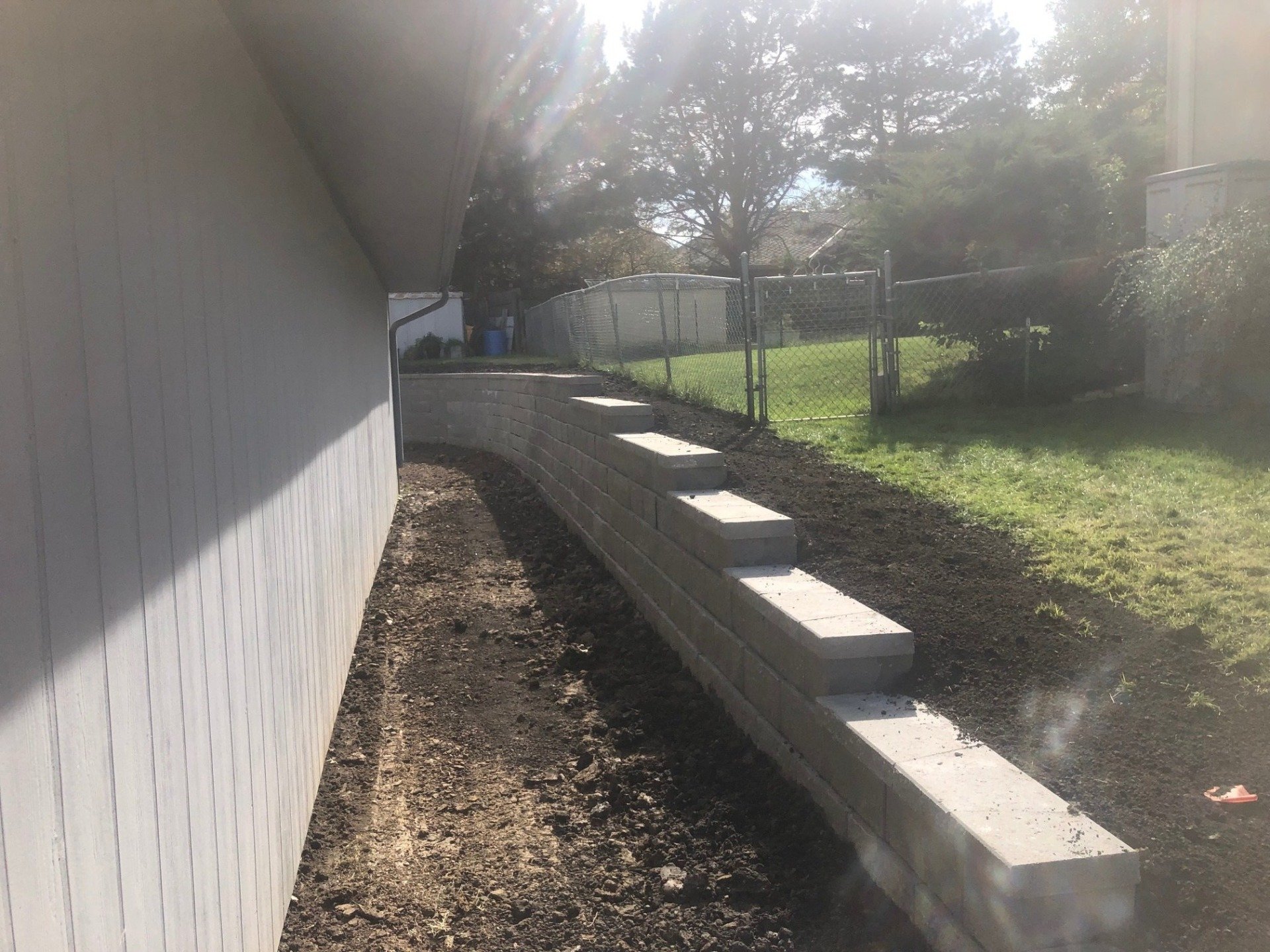 A concrete wall is being built in the backyard of a house.