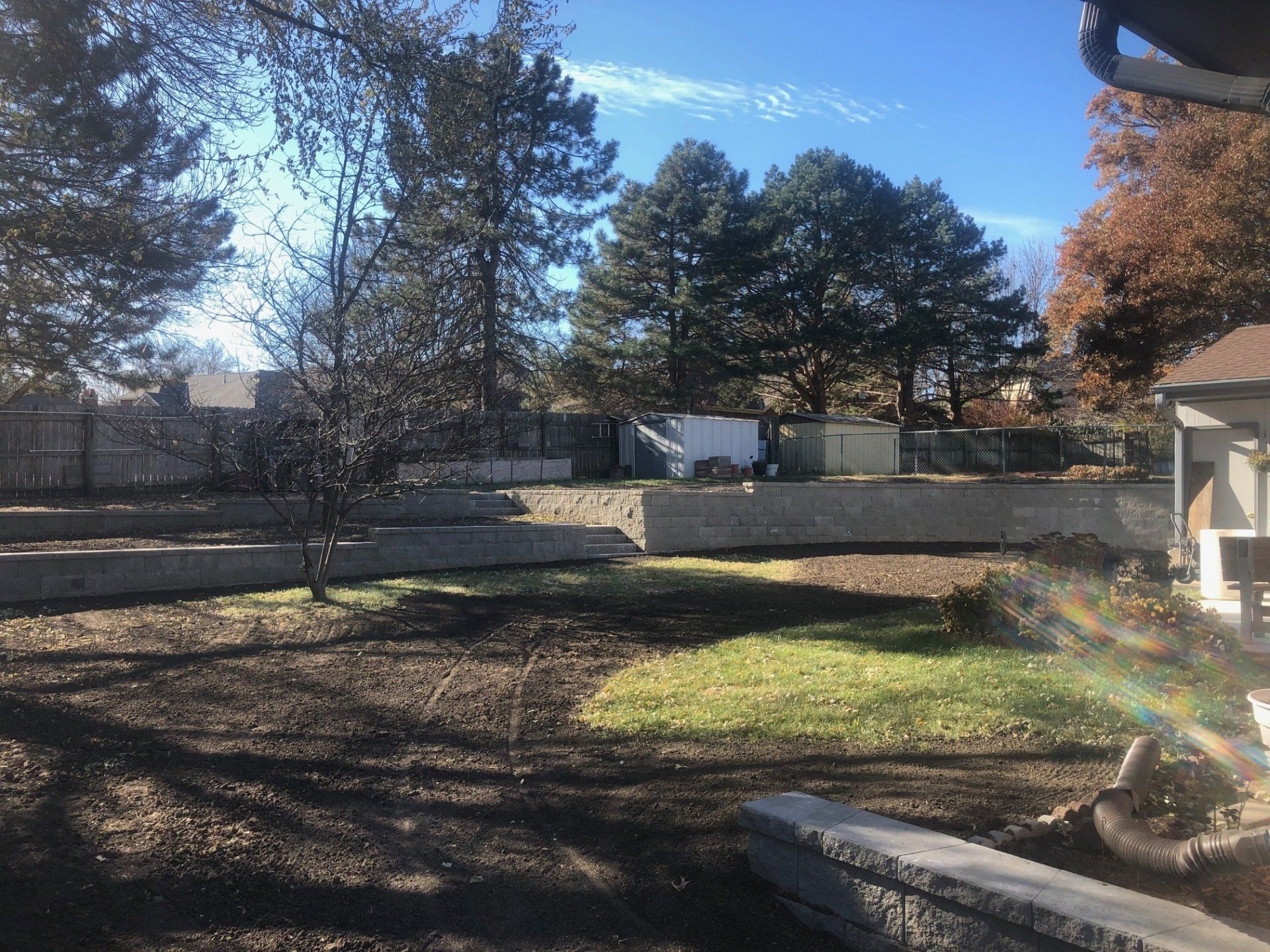 A fenced in yard with trees and a house in the background