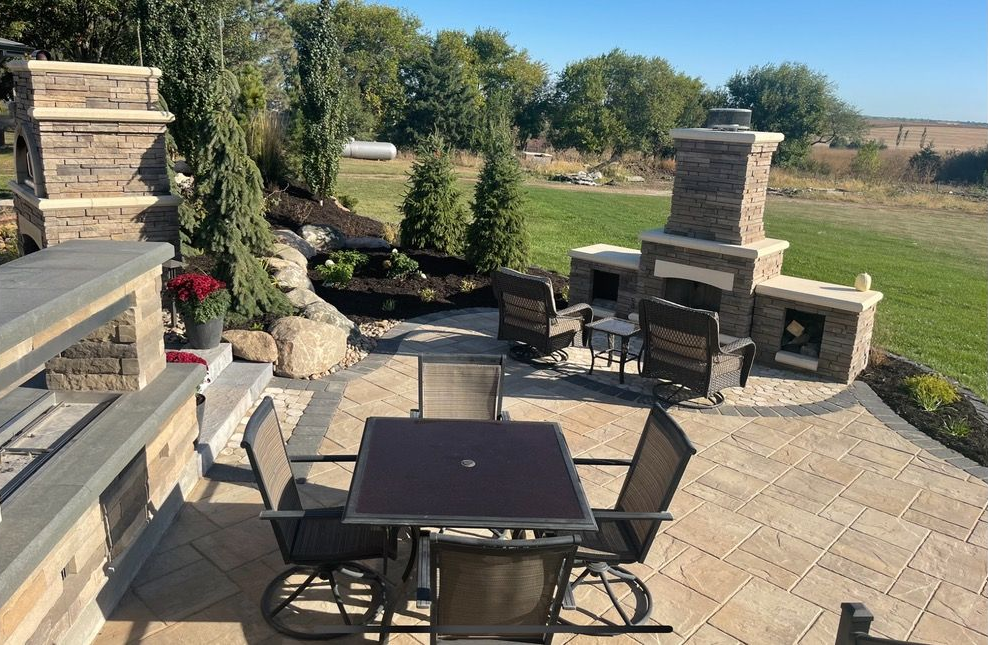 Outdoor patio with fireplace, seating, and water feature.