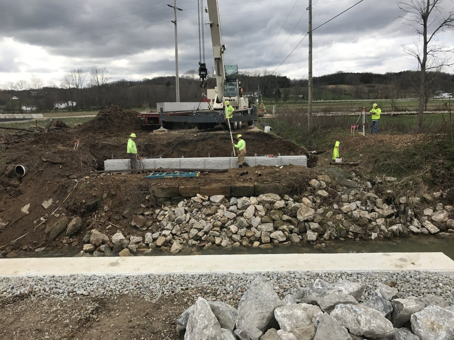 A group of construction workers are working on a bridge over a river.