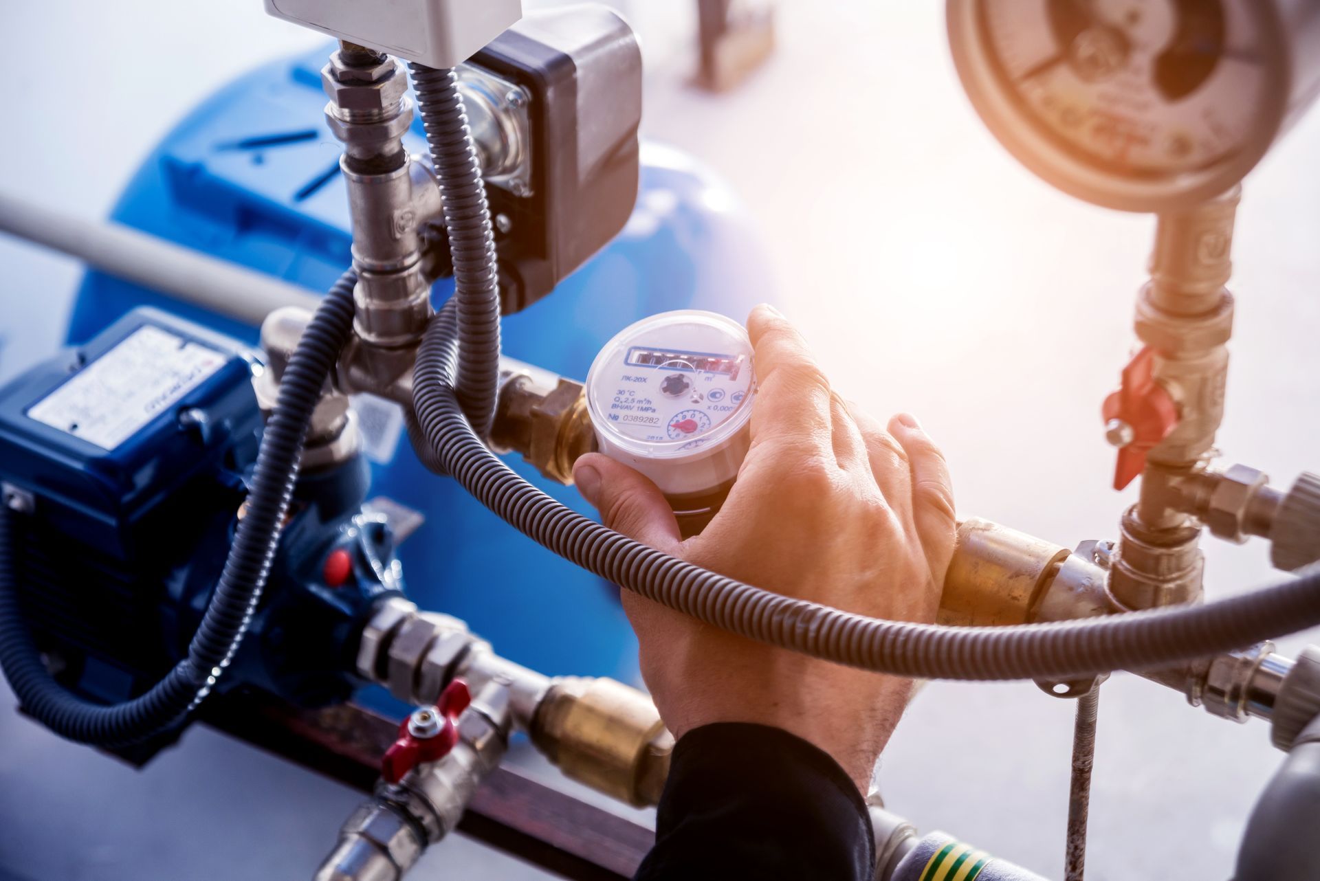 Close-up of professional hands during a water pump repair and water meter maintenance service.