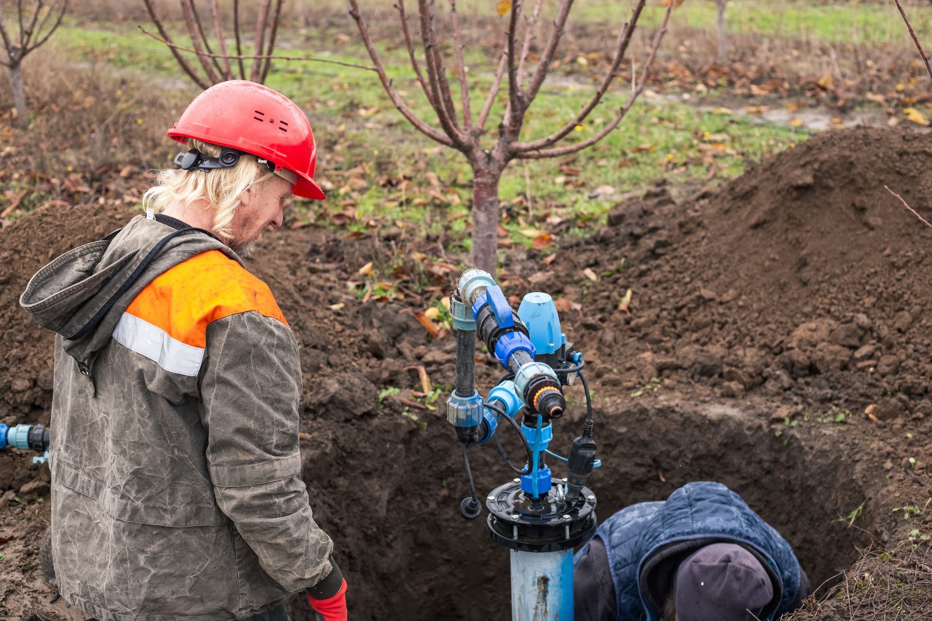 Professional technicians performing an emergency water pump repair for a residential well system.