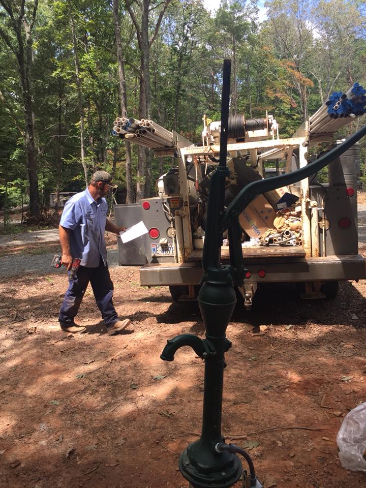 Water Softeners — Man and Hand Pump at the Back of the Car in Salisbury, NC