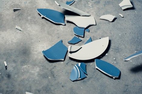 A broken blue and white plate is laying on the ground