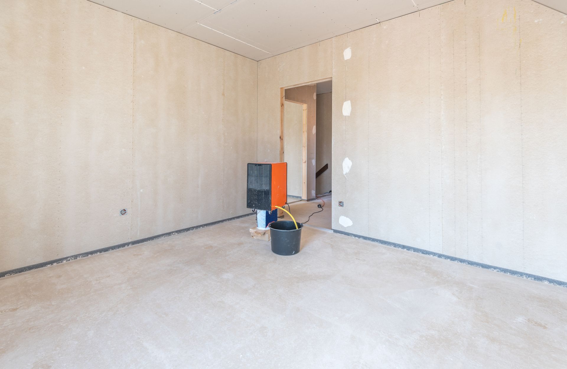 Une pièce vide avec un seau et une boîte à l'intérieur.