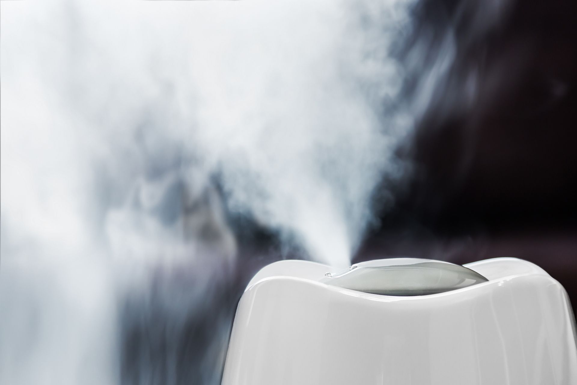 Un gros plan d'un humidificateur blanc avec de la vapeur qui en sort.