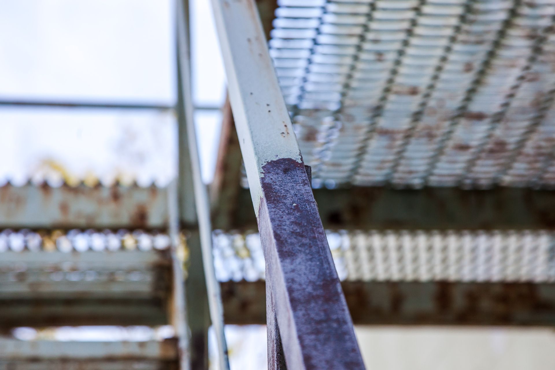 Un gros plan d'une rampe en métal rouillée sur un escalier.