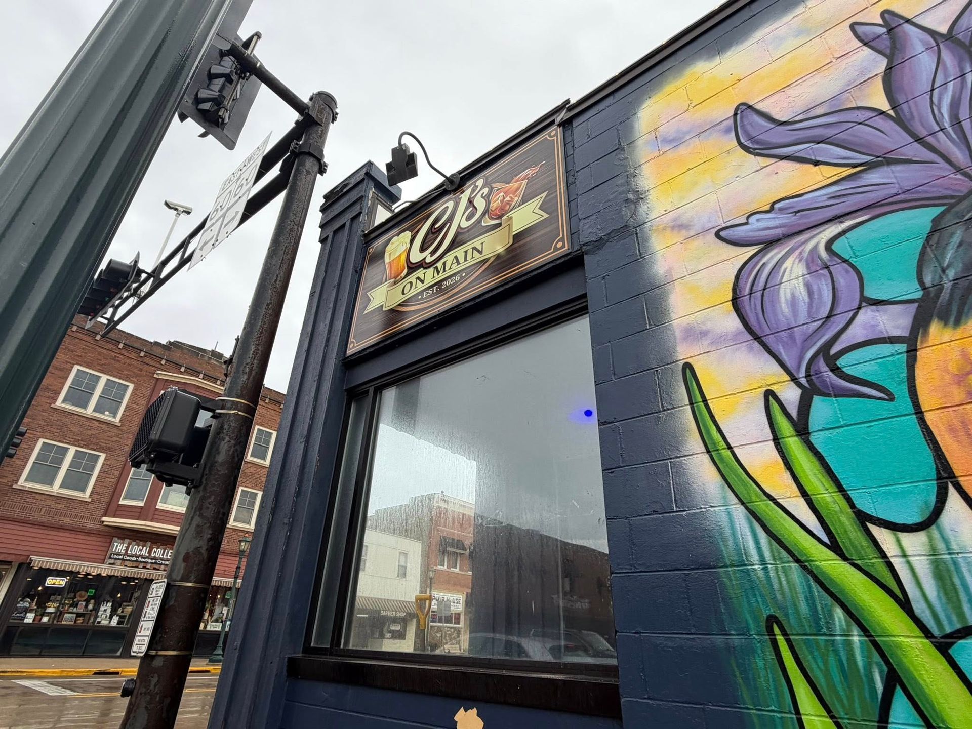 A live band performs on a stage with colorful spotlights before an audience in a dark, indoor venue.
