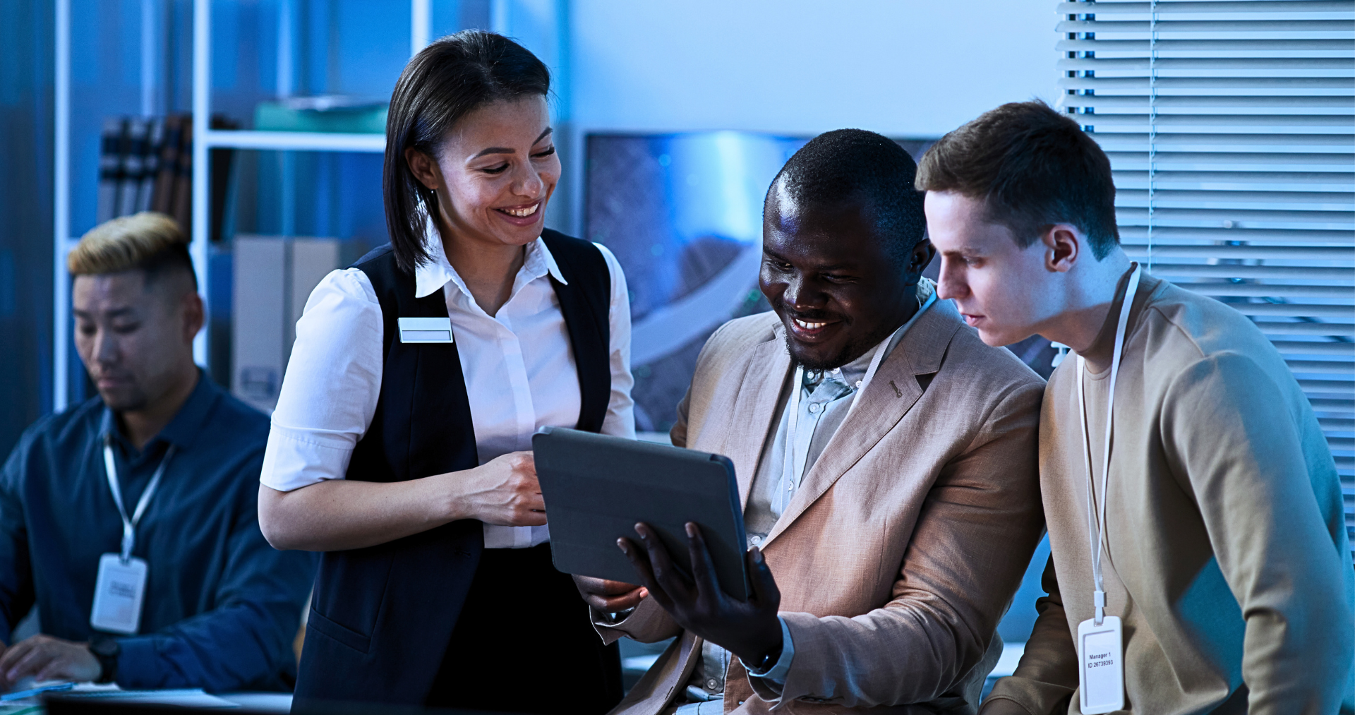 A group of people are looking at a tablet together.