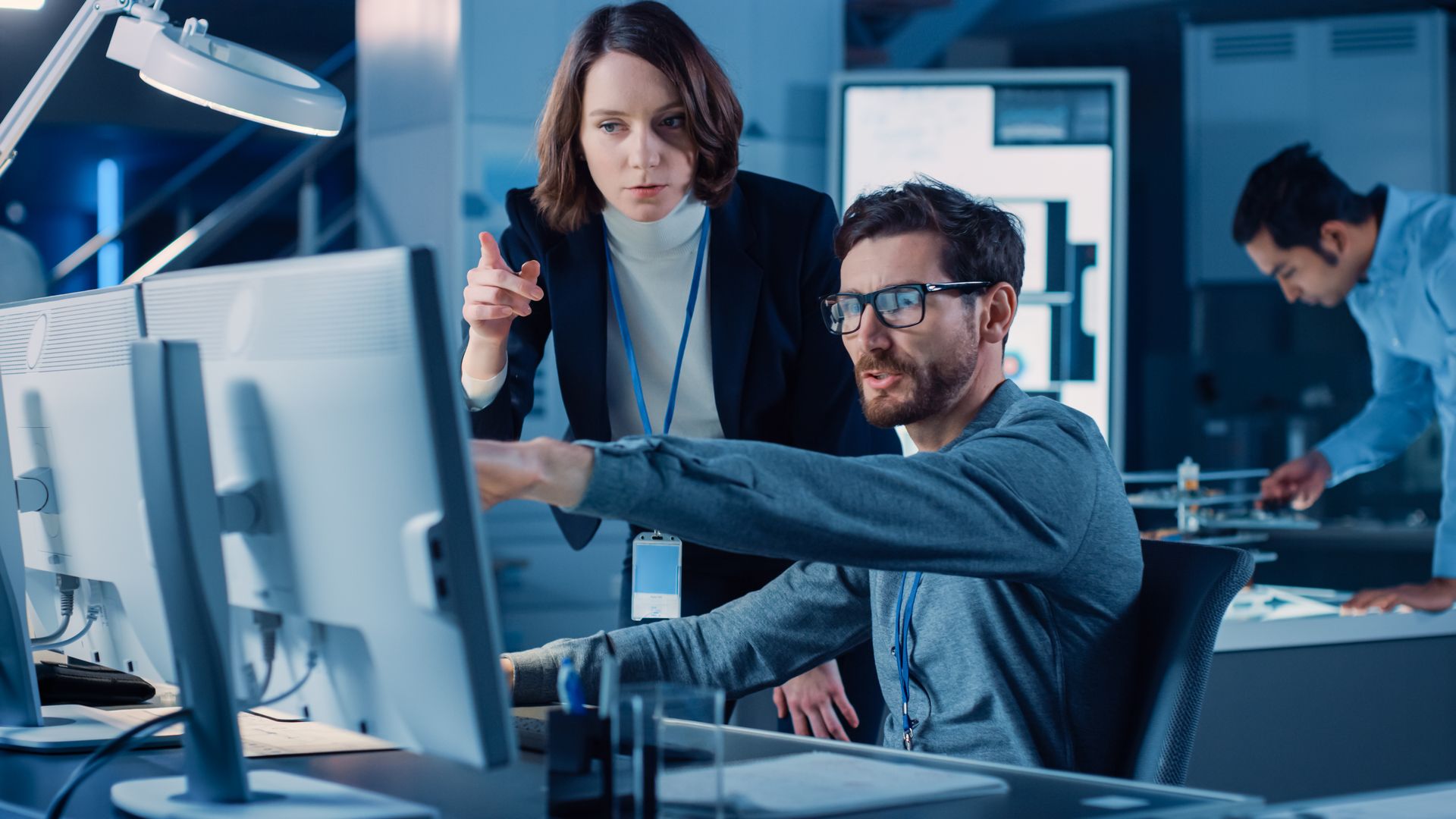 A man and a woman are looking at a computer screen.