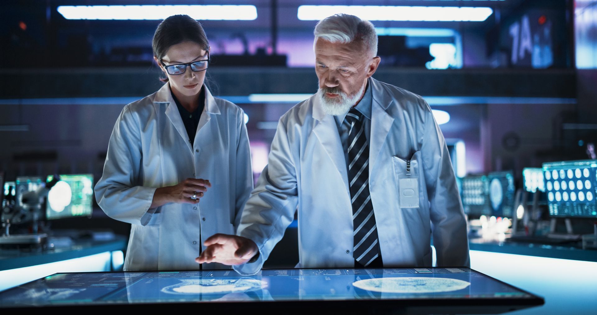 A man and a woman are looking at a computer screen.