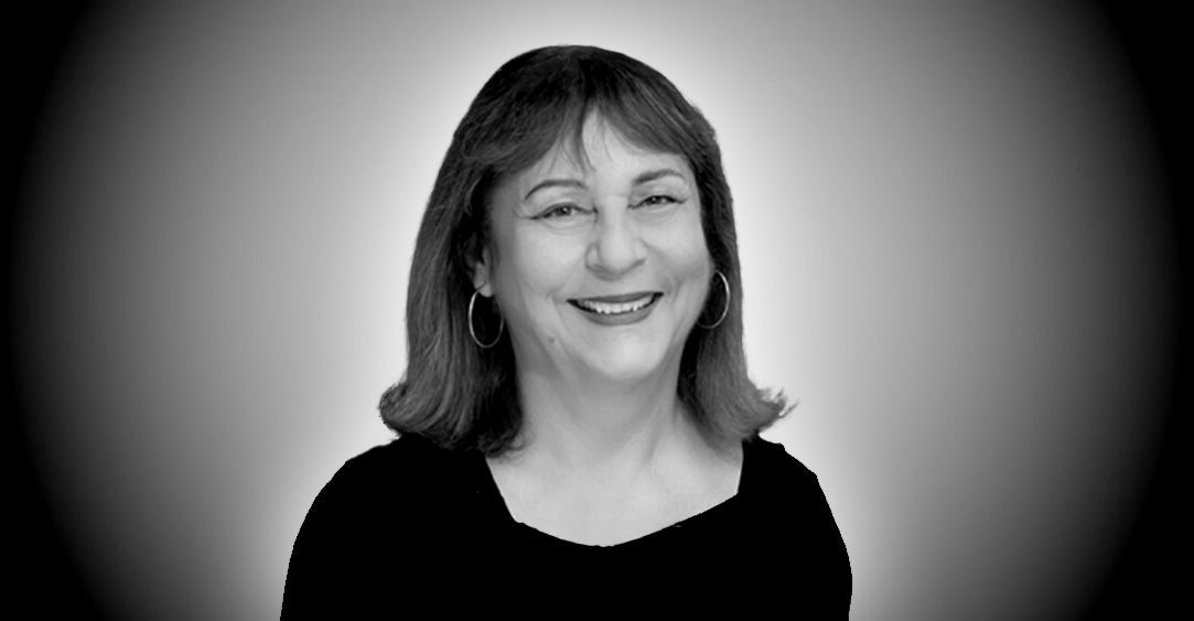 A woman is smiling in a black and white photo.