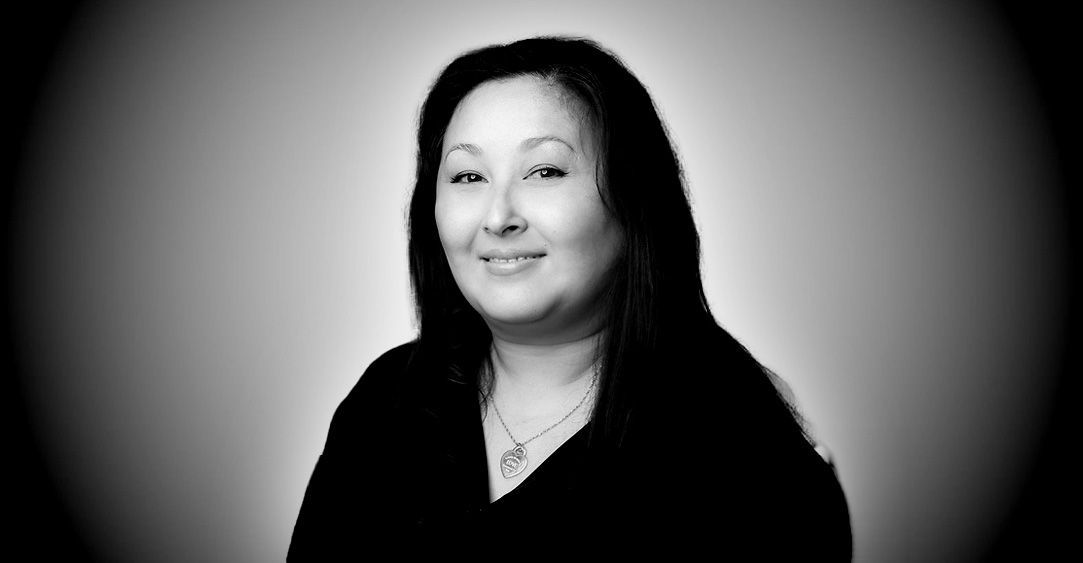 A black and white photo of a woman with long hair and a necklace.