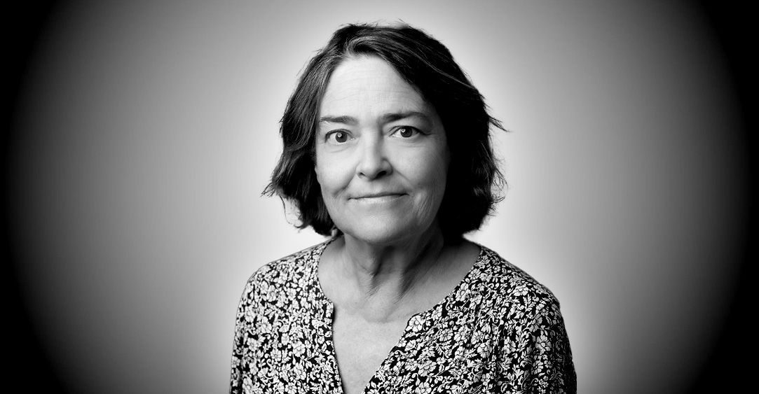 A black and white photo of a woman in a floral shirt.