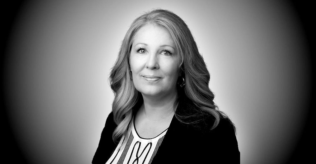 A woman is smiling in a black and white photo.