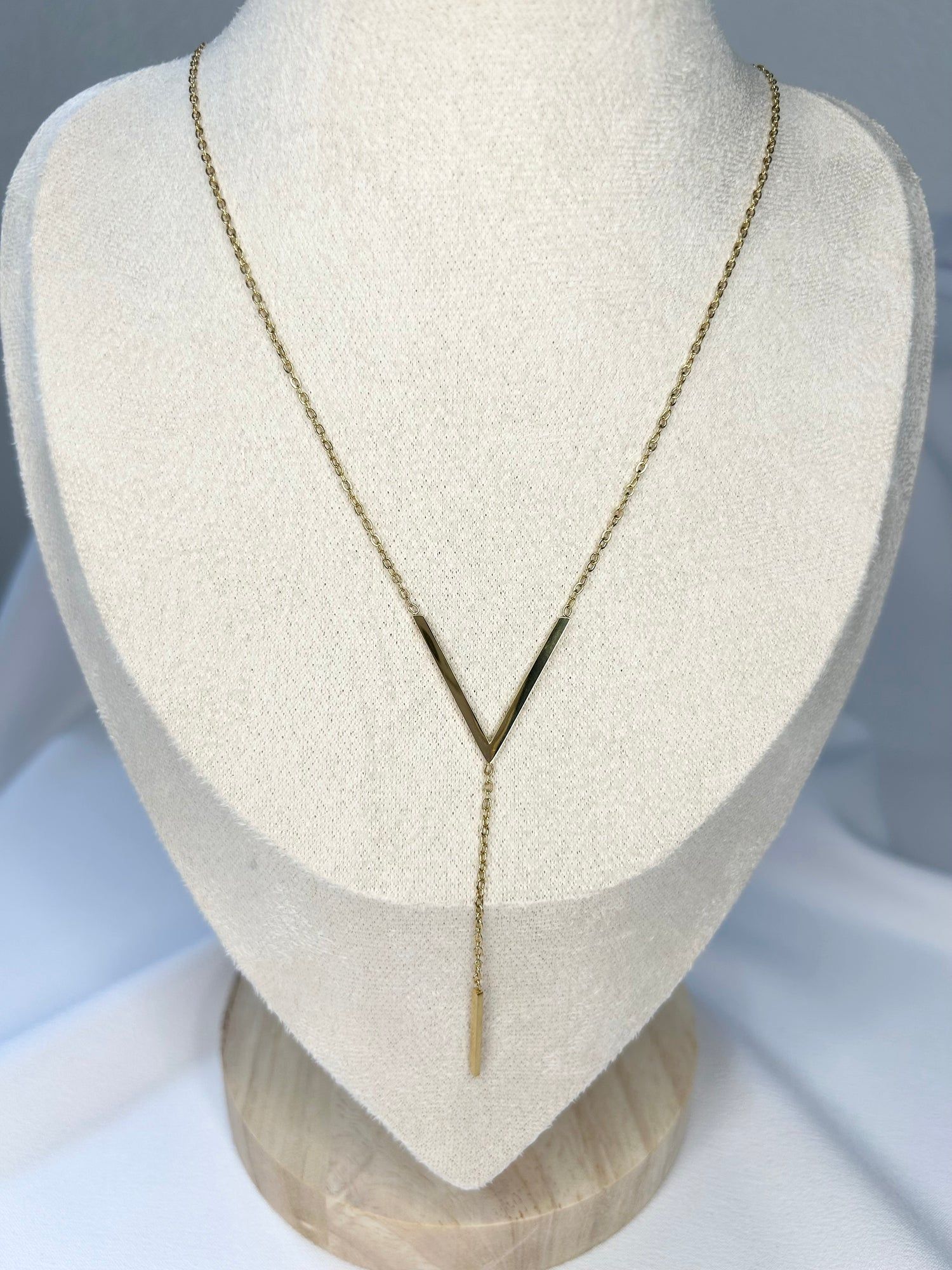 Un collier en or est sur le cou d'un mannequin.