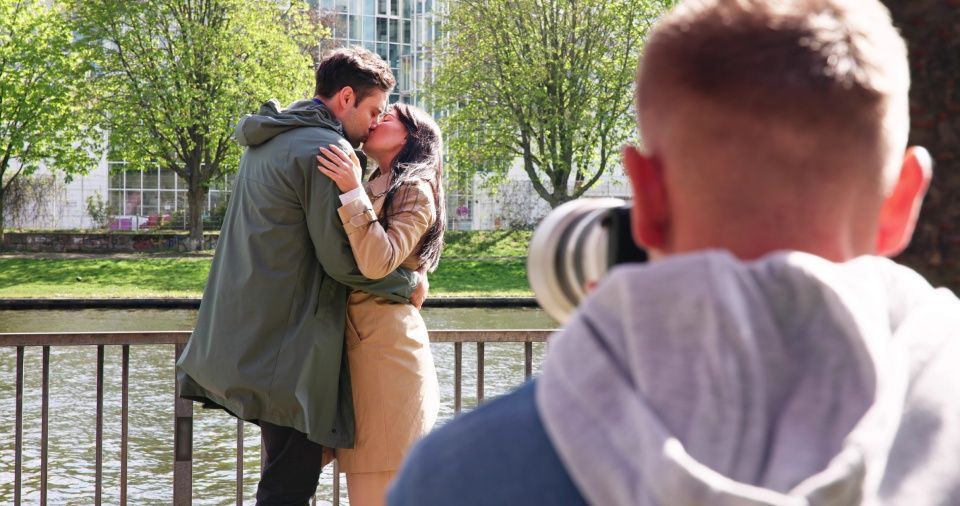 Photographer with two people kissing