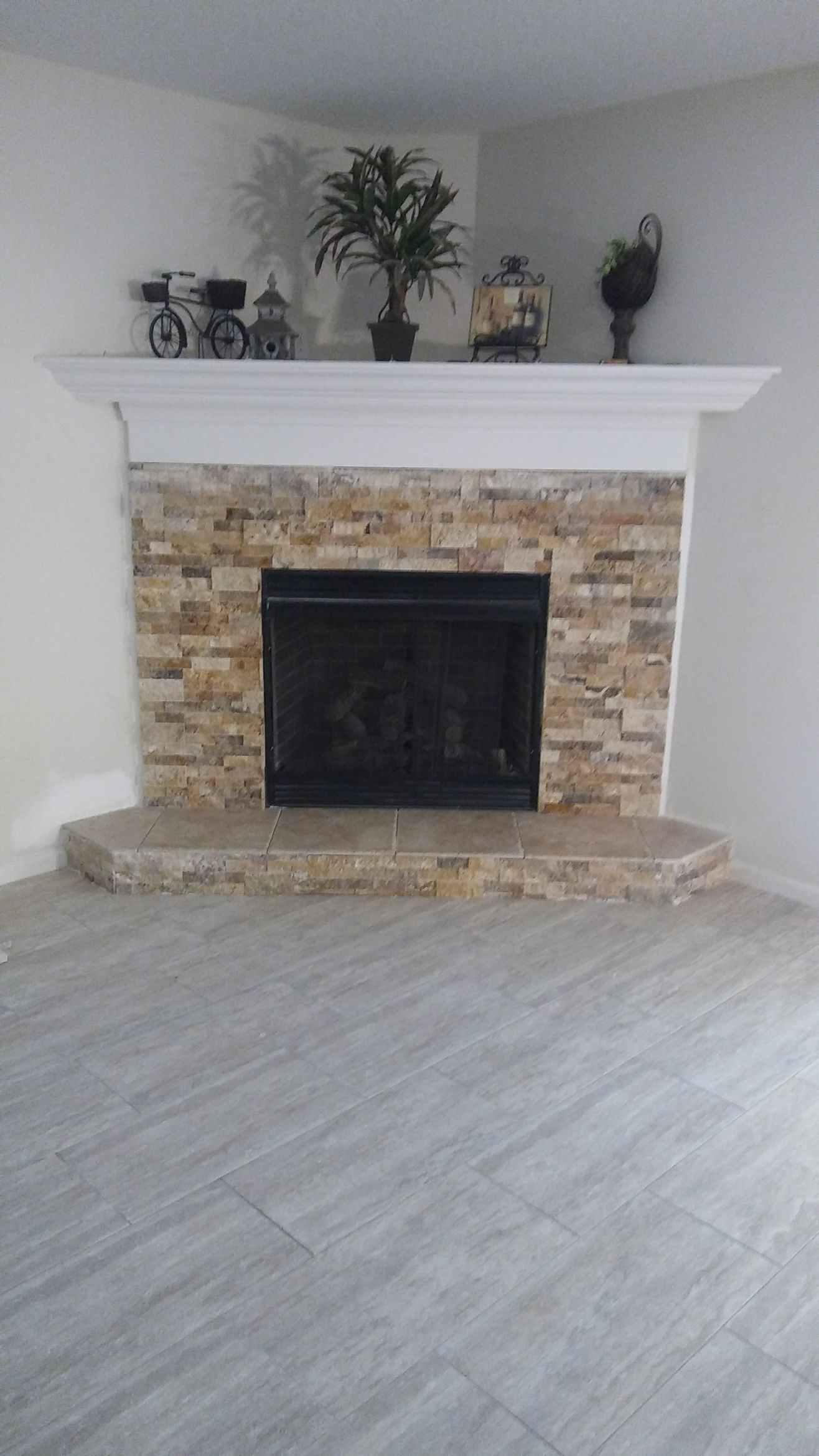 Fireplace with burning logs, brick surround, tools, black background.