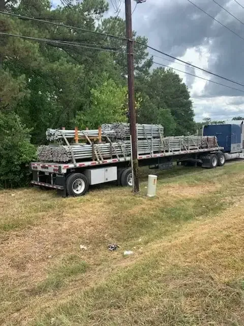 A semi truck is carrying a load of scaffolding on a flatbed trailer.