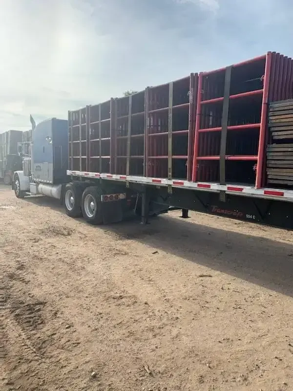 A semi truck is carrying a trailer filled with shelves.