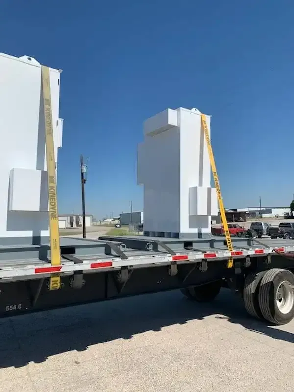 A semi truck is carrying a large white container