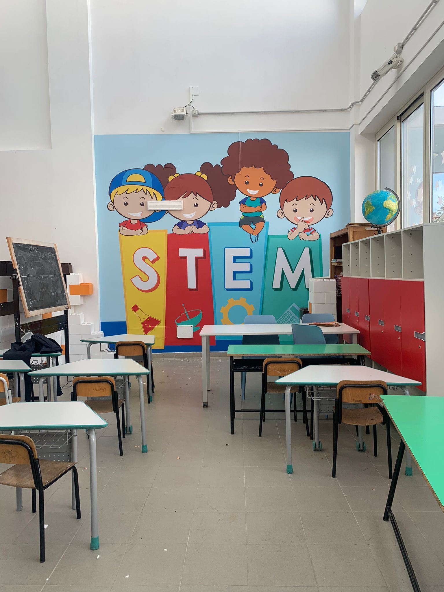 Aula scolastica con un murale