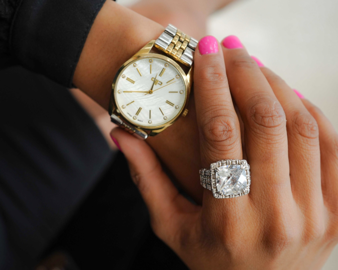 A woman wearing a POSH watch and a diamond ring