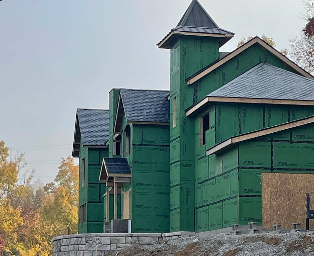 A house that is being built with green siding