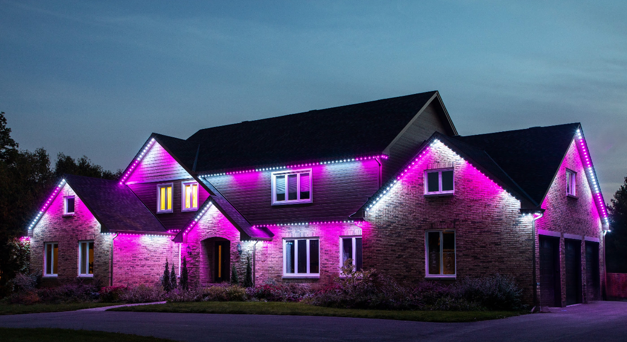 House with pink and white lights, dusk setting.