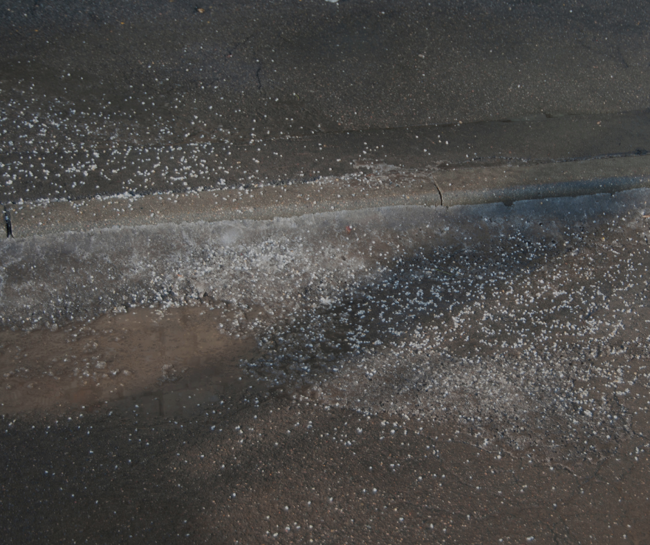 Salt granules scattered on asphalt.