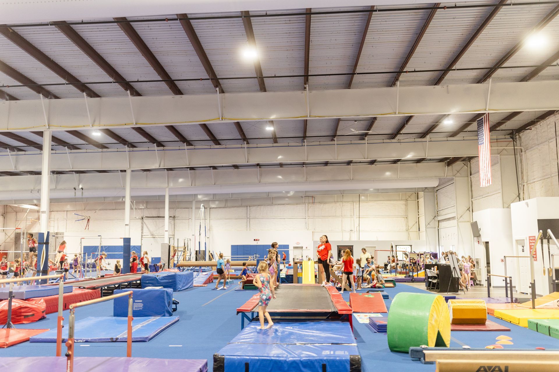 A large gym filled with lots of equipment and people.