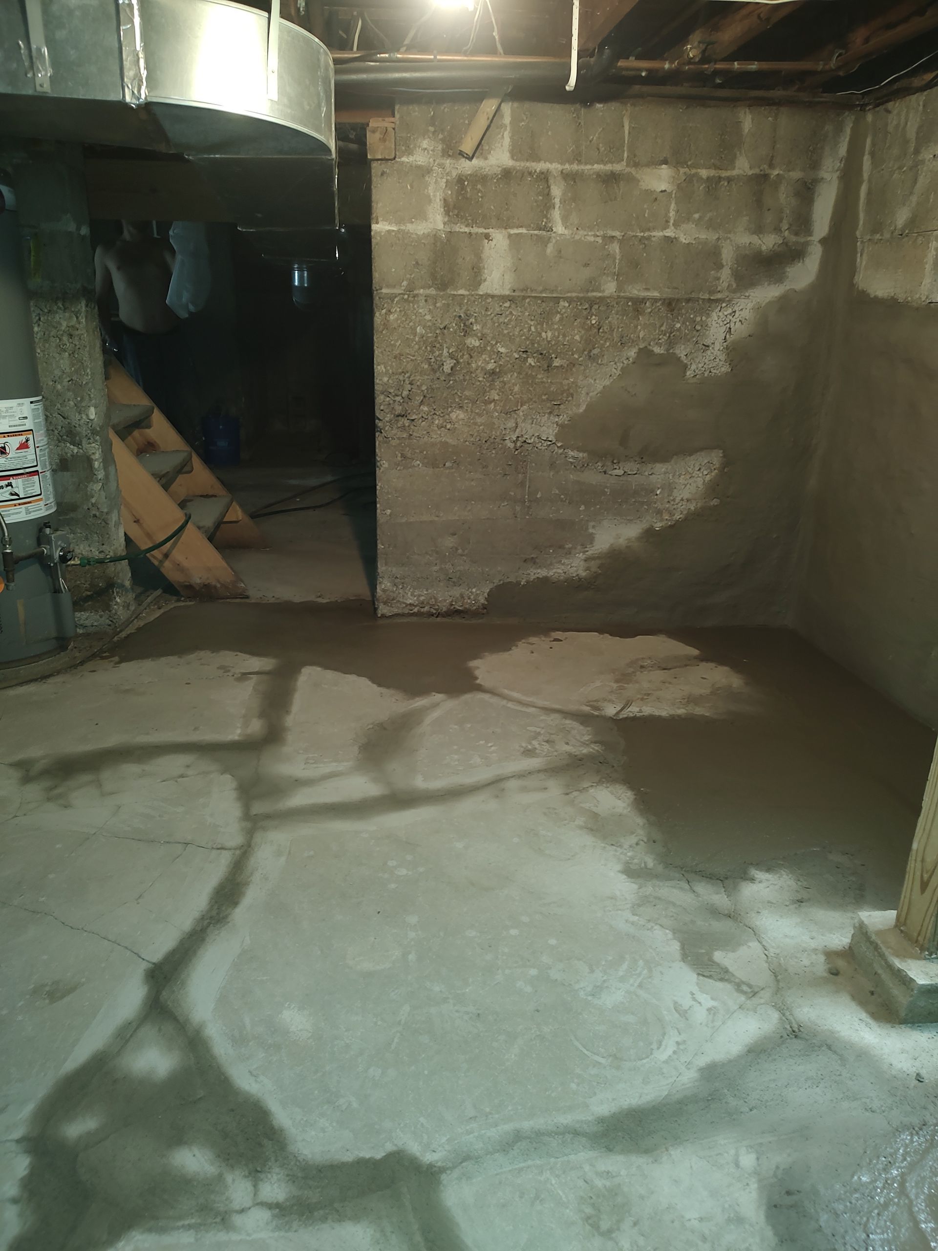 A basement with a concrete floor and brick walls.