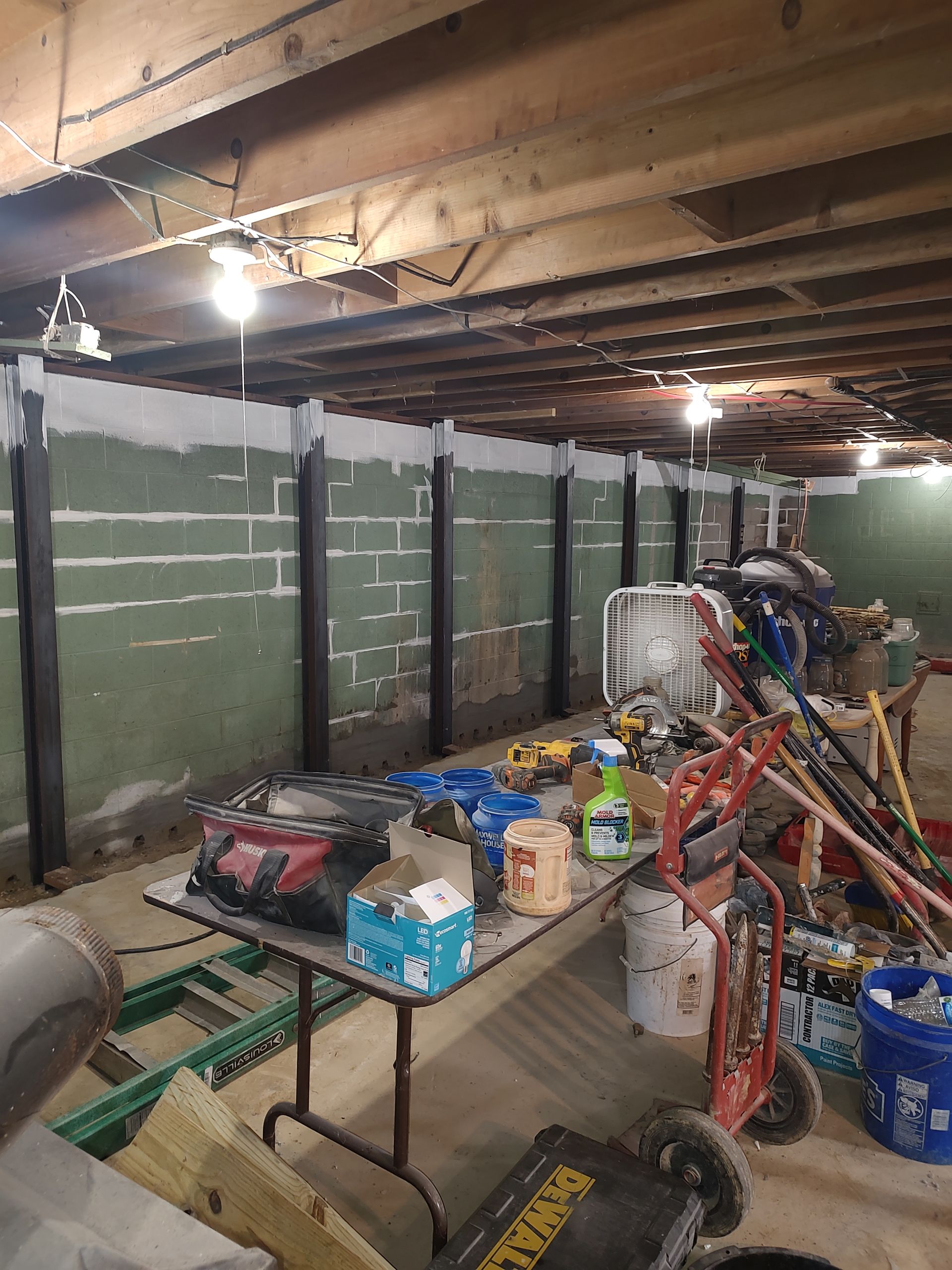 A basement with a table and a bunch of tools on it.