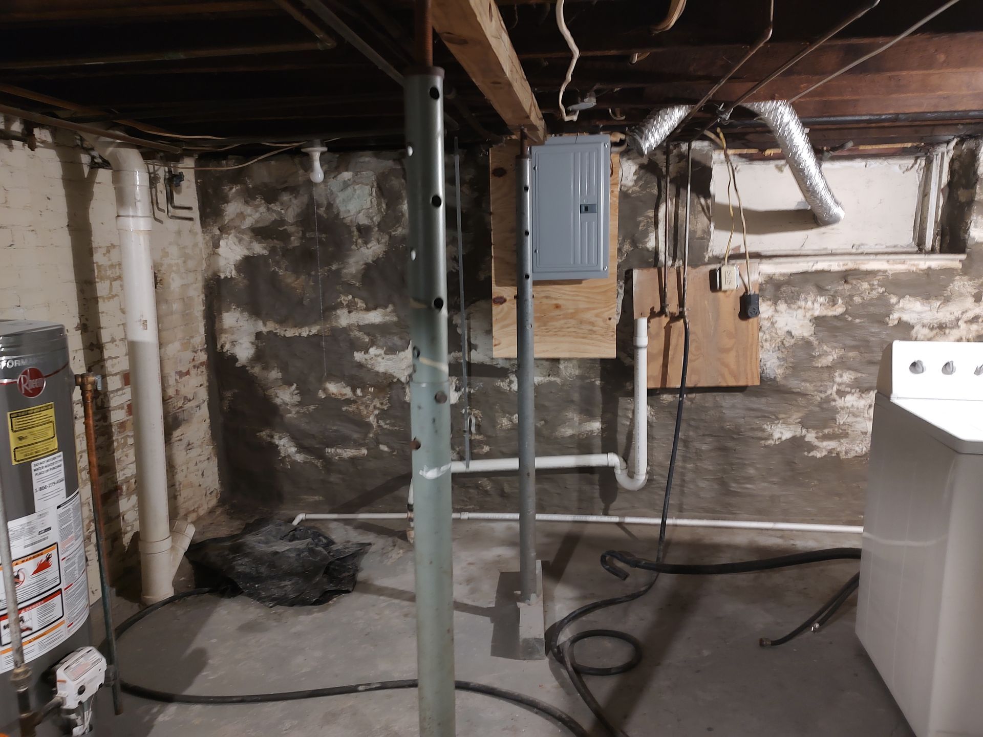 A basement with a water heater and a washer and dryer