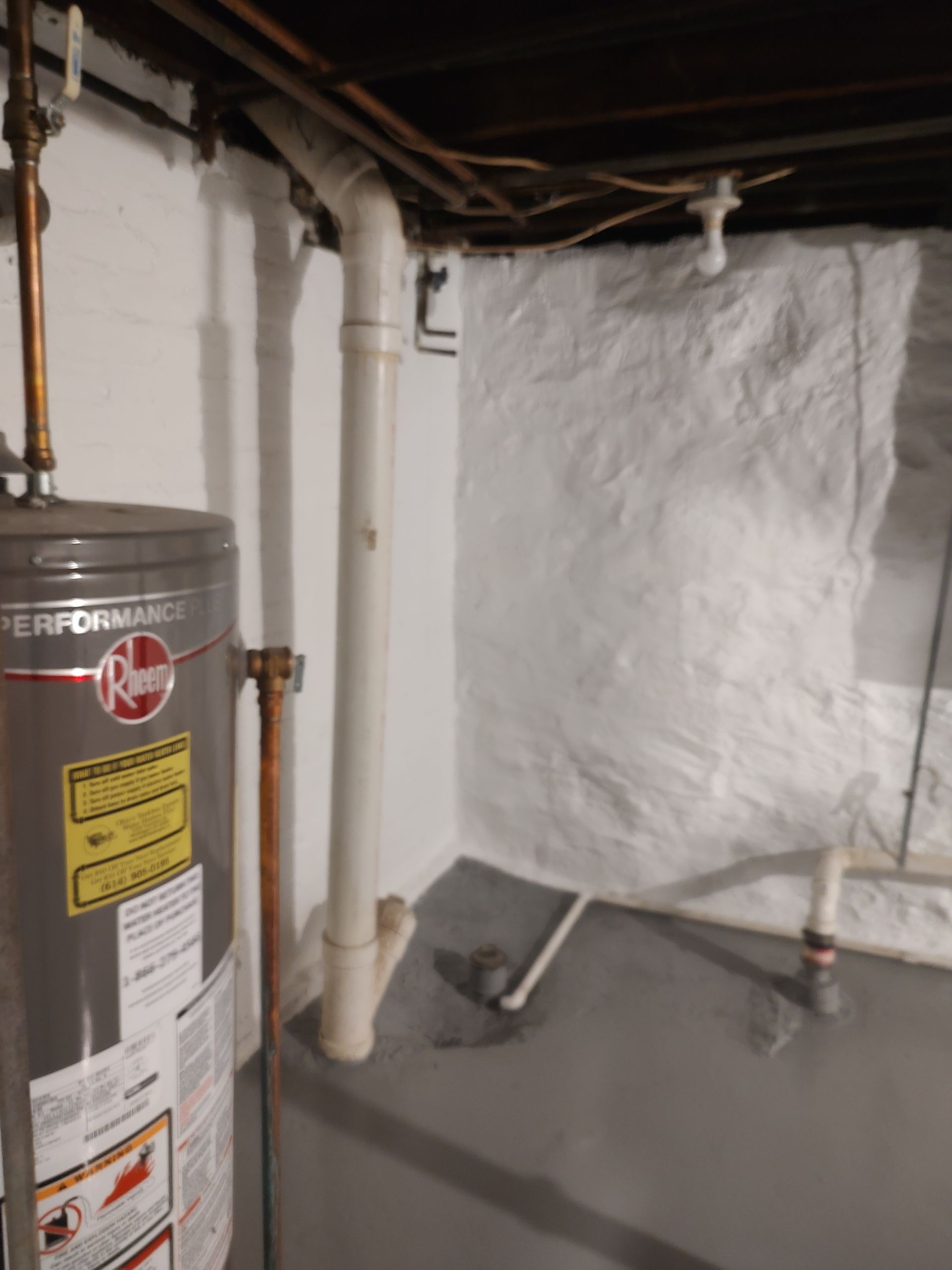 A hoover water heater is sitting in a basement