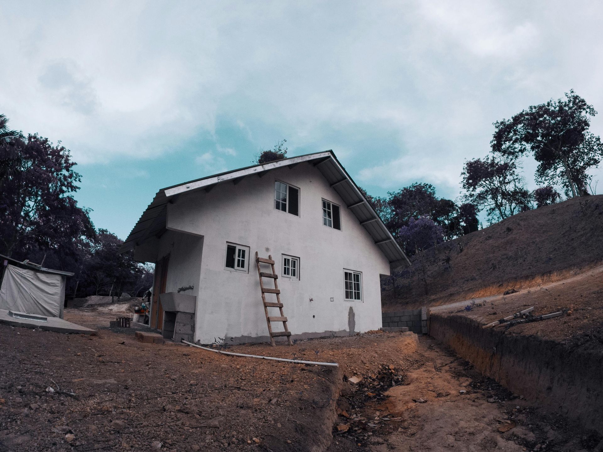 A white house with a ladder in front of it