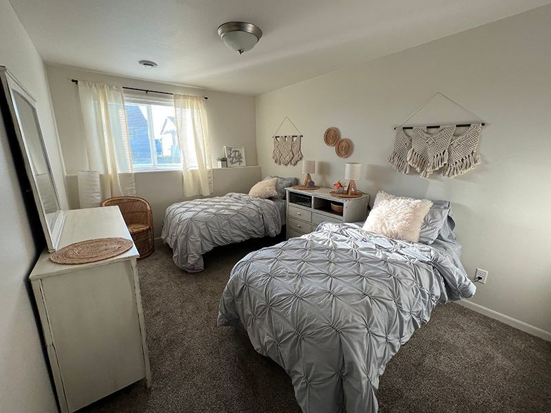 neatly made twin beds in a bedroom