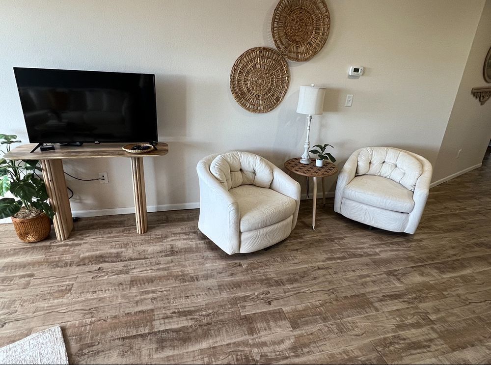 two nice white living chairs and wall art