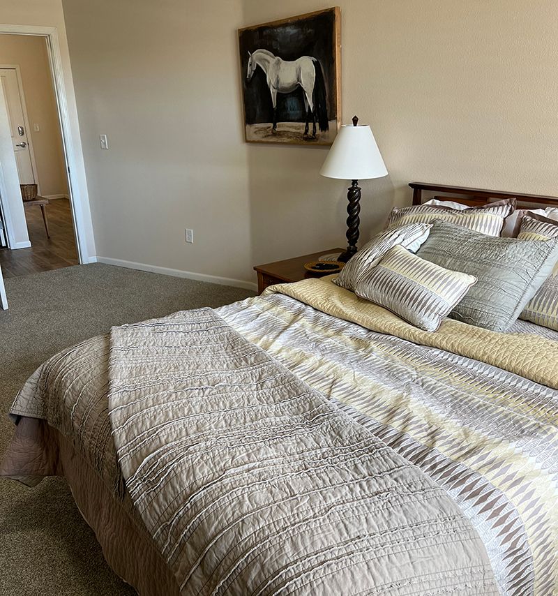 nicely made bed with light colors