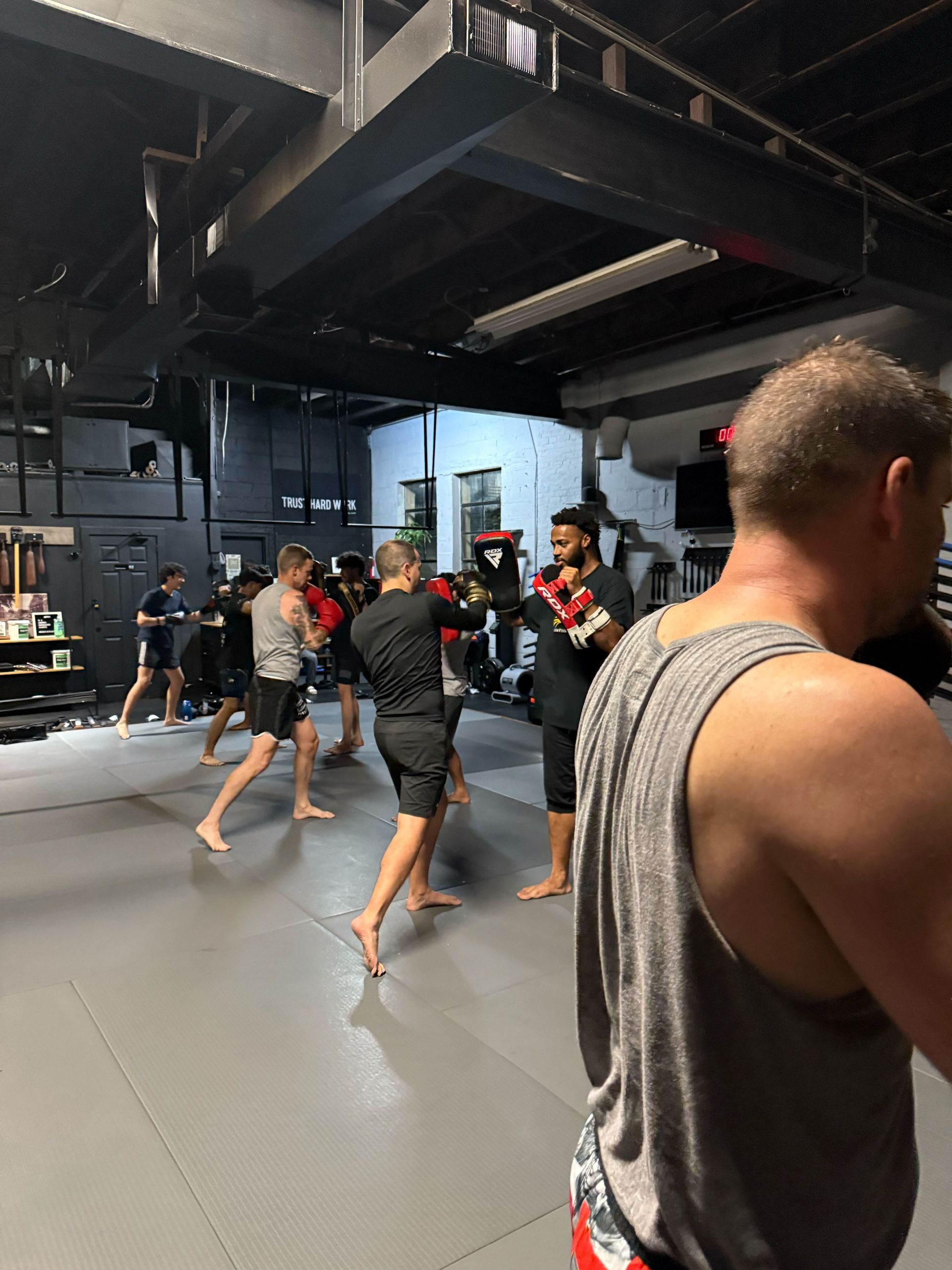 Adults practicing takedown balance drills at Bodega Jiu-Jitsu in Maplewood, NJ.