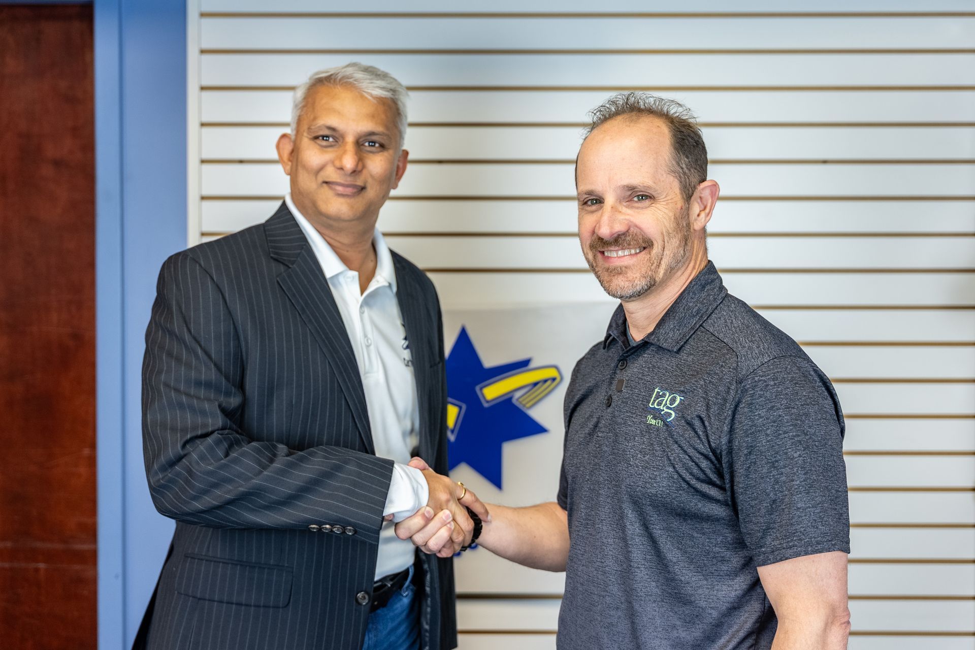 A woman is sitting in front of a printer and smiling.