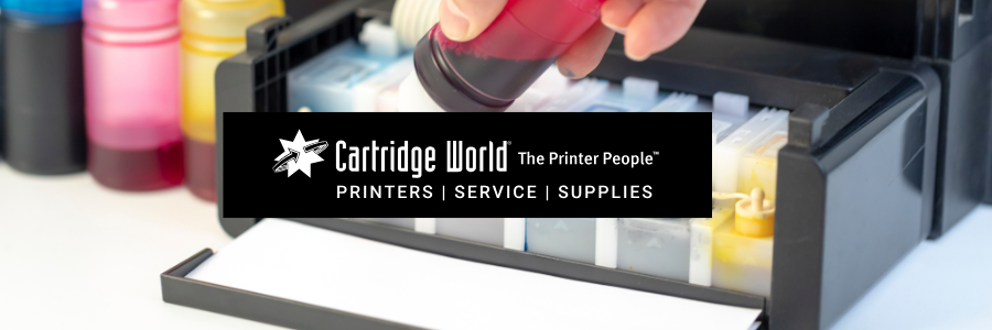 Person refilling a printer with red ink bottles, Cartridge World logo in view.