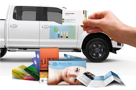 A person is putting a business card on the side of a truck.