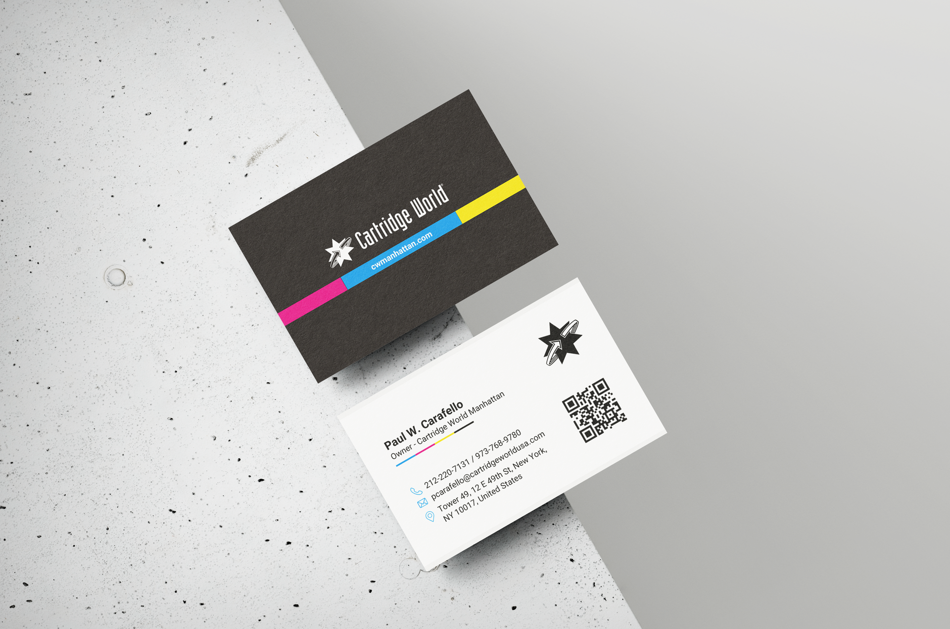 Two business cards are sitting next to each other on a table.