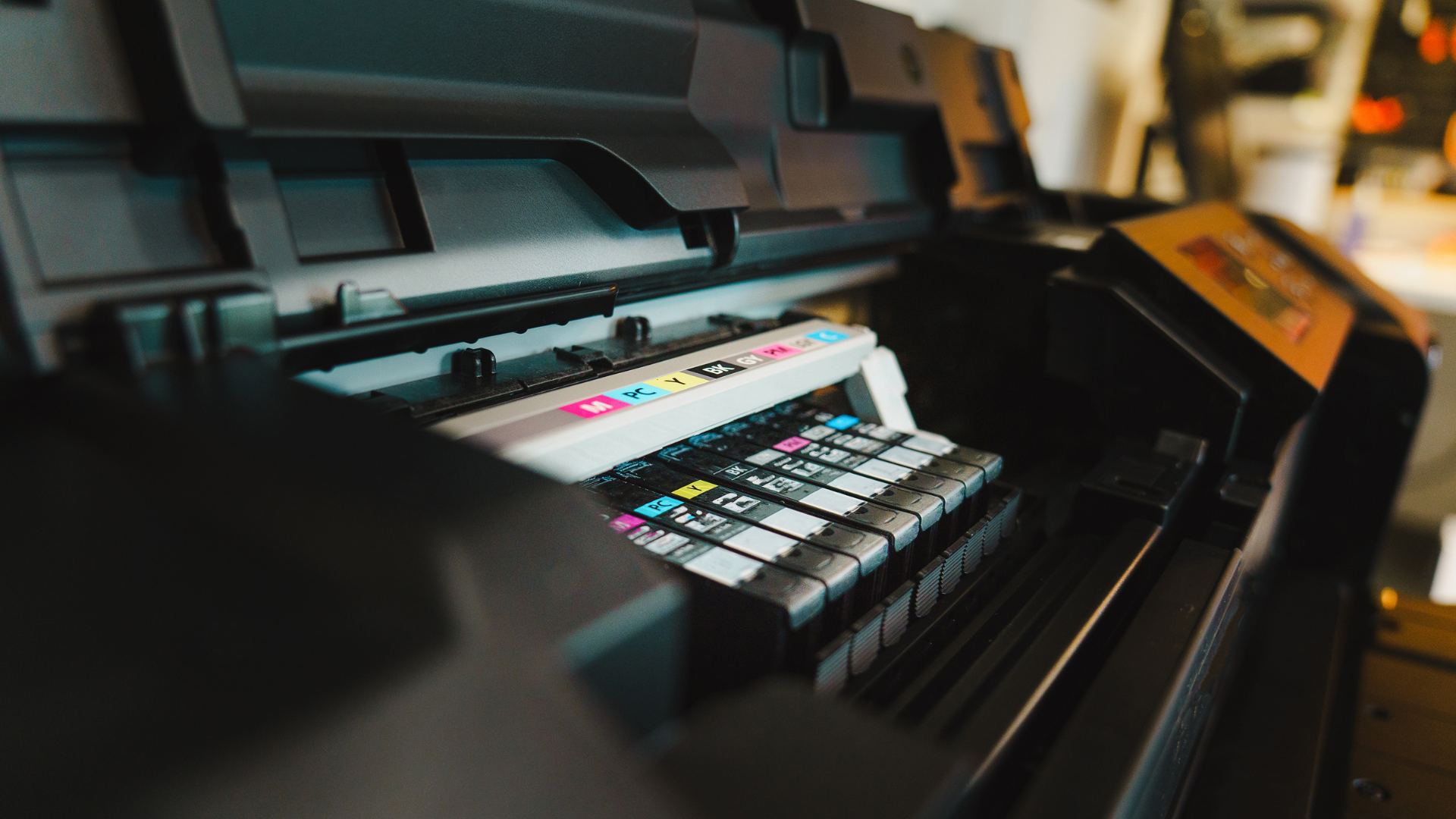 A man in a suit and tie is sitting in front of a printer.