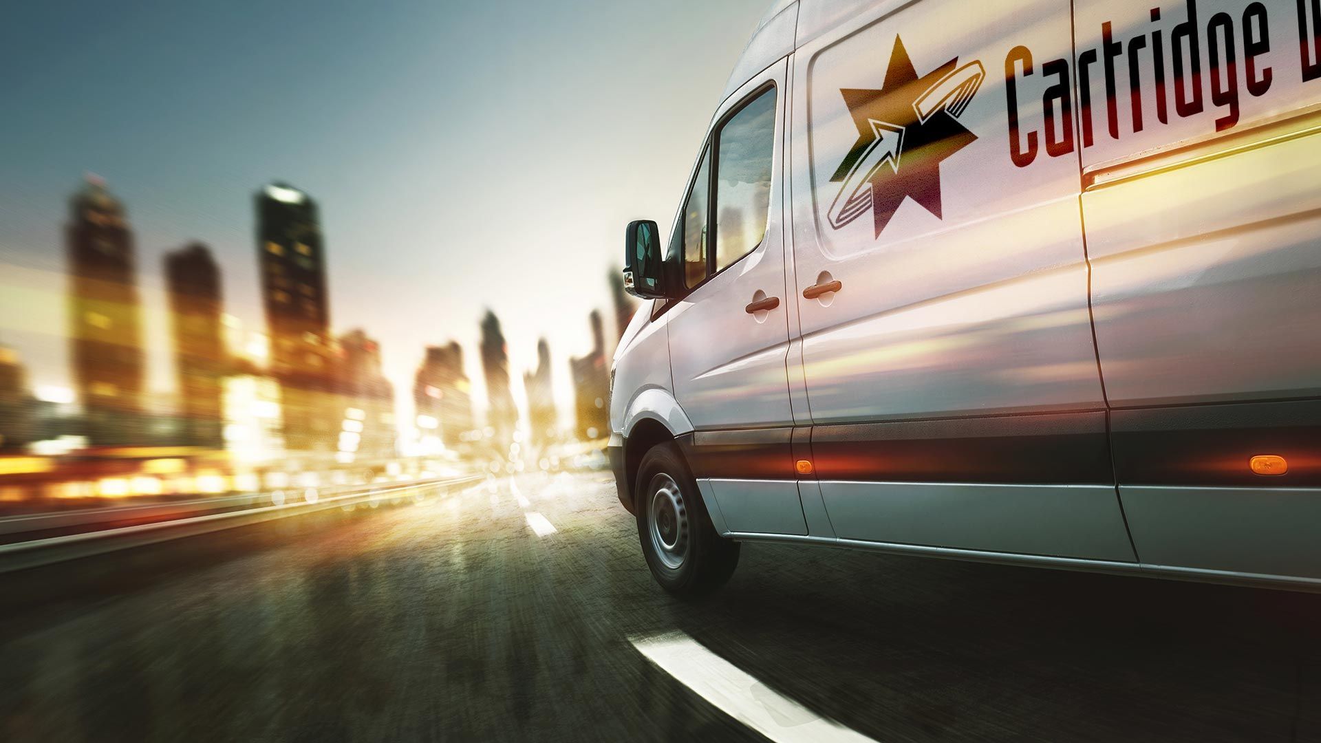 A cartridge van is driving down a highway in front of a city skyline.