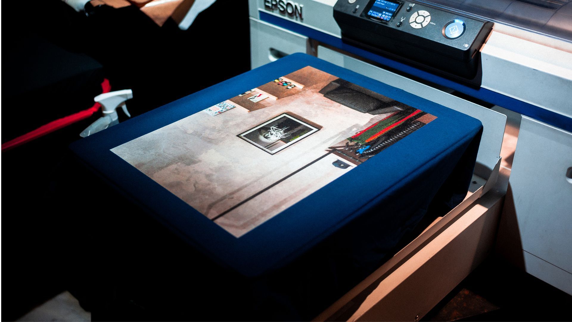 Blue kiosk with a touchscreen displaying a brochure or floor plan in a dim exhibit space