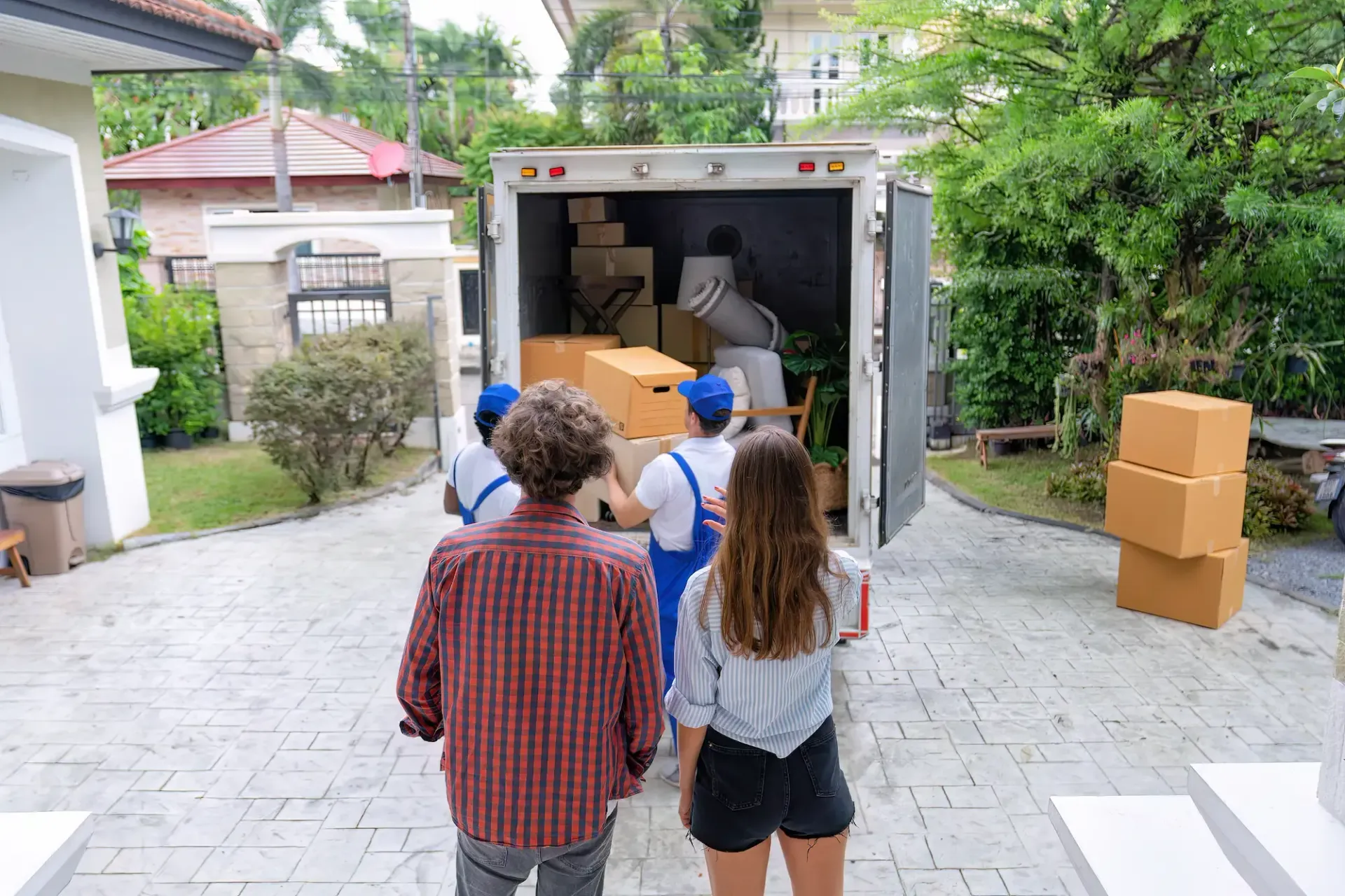 A group of people are standing in front of a moving truck.